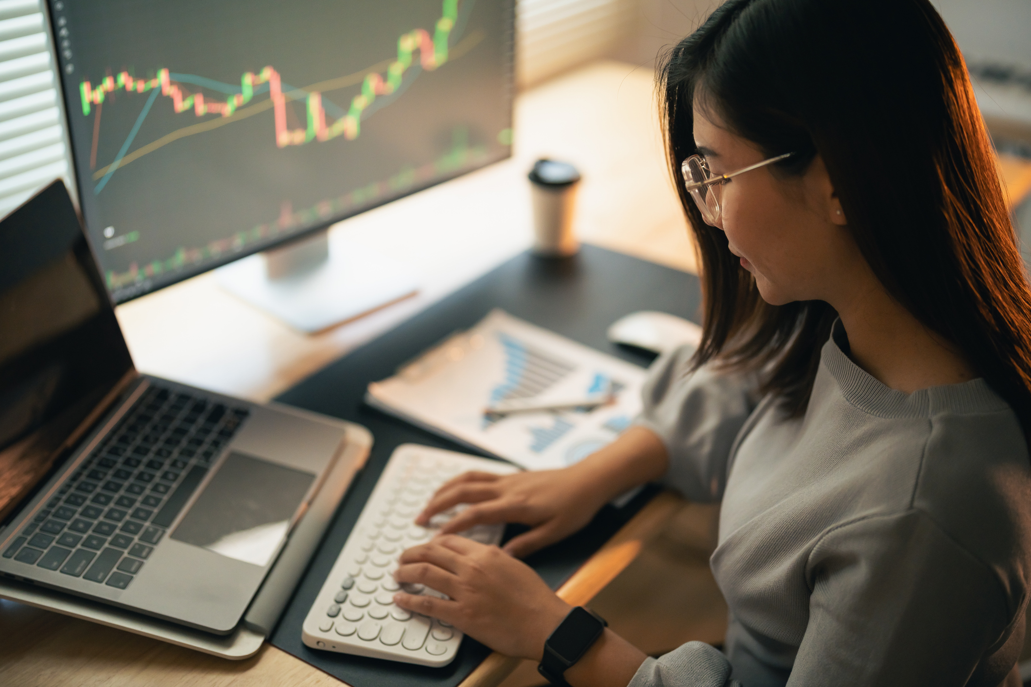 Young Asian woman checking stock options on a computer