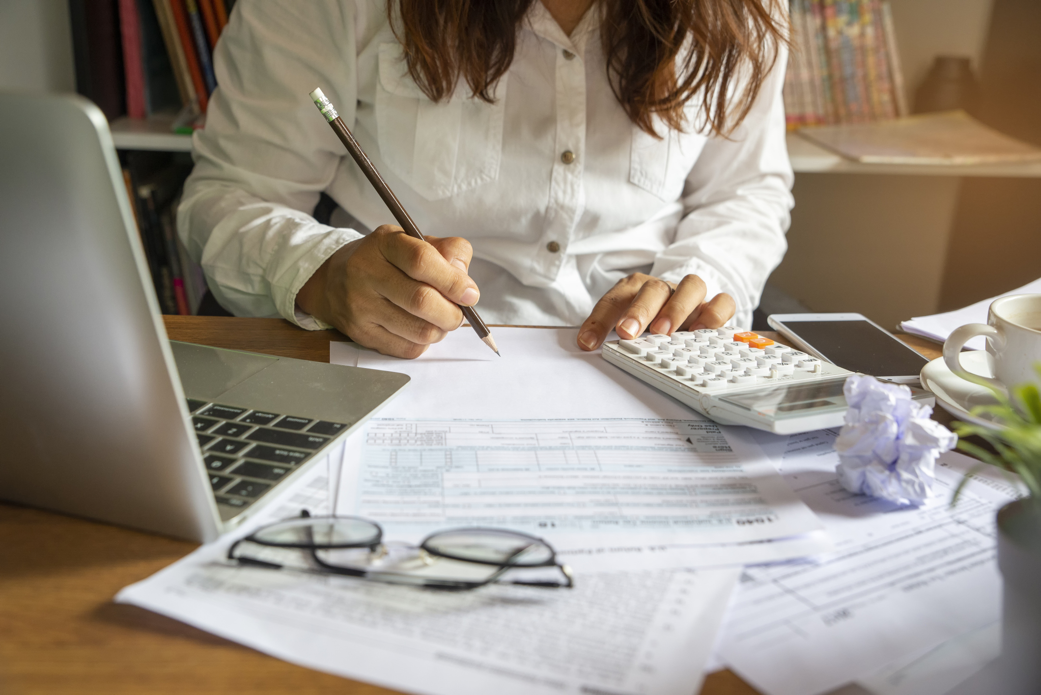 business woman sitting at a desk with papers and a calculator